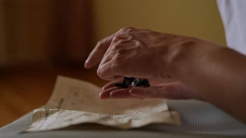 Détail recadré d'un homme méconnaissable lisant des instructions tenant des boulons pour assembler un ordinateur