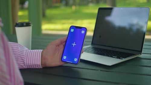 Woman Hand Holding Phone with Chroma Key Screen Outdoor Smartphone with Green Screen Closeup