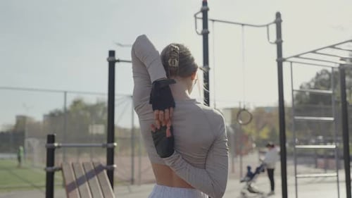Back View on Woman Has Workout Outdoors and Doing Stretching Exercises