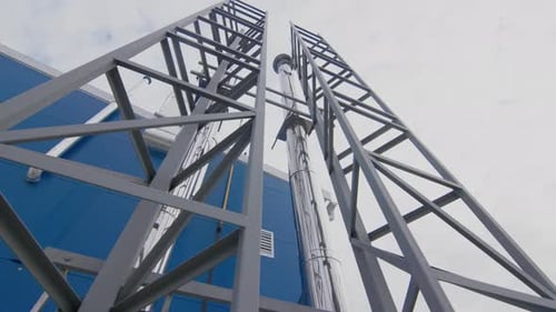 Rohrleitungen und Stützpfeiler an der Wand eines Industriegebäudes