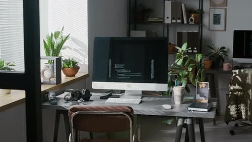 Programming Code Running on Screen of Computer Monitor on Work Desk