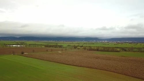 Ascendiendo sobre un campo agrícola con montañas de fondo durante un día de otoño, Alemania.