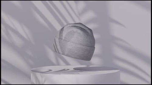 Grey Knitted Beanie Hat Floating on a Minimalist Pedestal with Palm Shadows