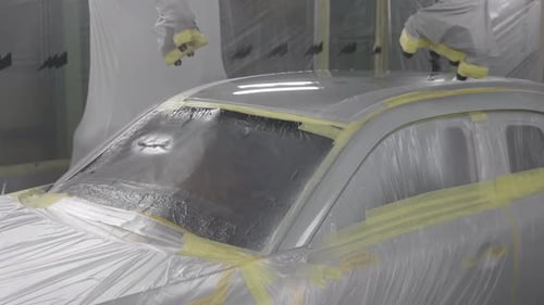 Robotic arms spray painting a vehicle body at a car manufacturing factory. Automobile factory.