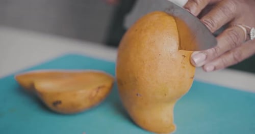 Woman Cuts a Fresh Mango into Pieces