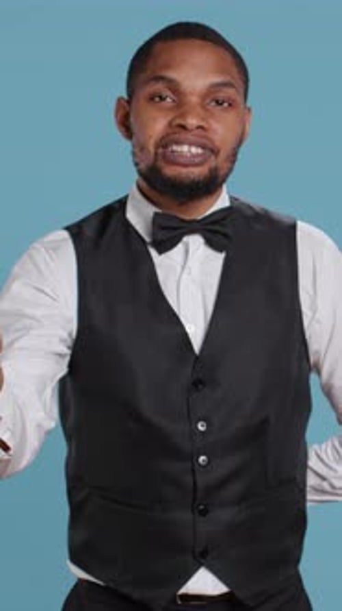 Vertical Video Friendly Doorkeeper at Five Star Hotel Greeting Guests and Offering His Services