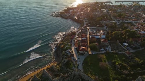 Aerial Sunset View of a Historic Coastal Town and Rugged Shoreline