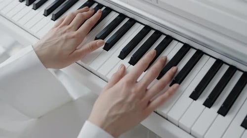Hands Playing a White Piano Keyboard, Close Up