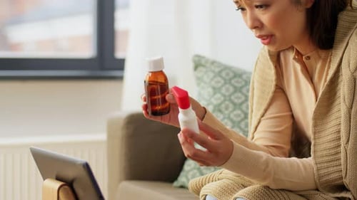 Woman Holding Medicine Bottles During Telehealth Consultation