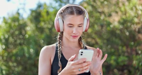 Woman with Headphones Using Smartphone Outdoors