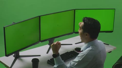 Man Celebrating And Dancing While Working With Mock Up Multiple Computer Monitor In Green Screen