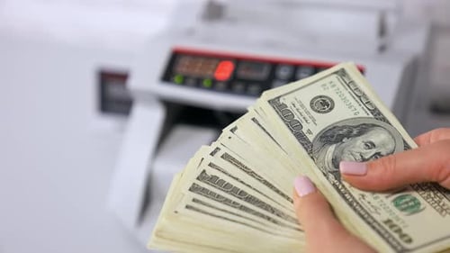 Dollar banknotes in woman's hands.