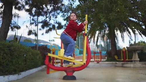 Girl Exercising on Machine in Urban Park