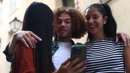 Friends Looking at Smartphone on Urban Street