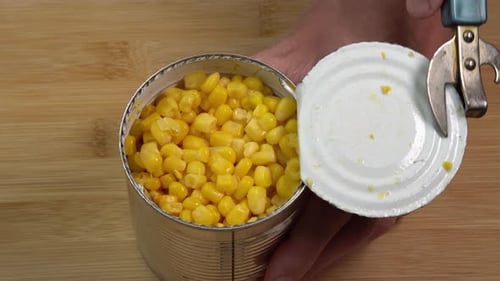 Can Opener Opening Can of Yellow Corn