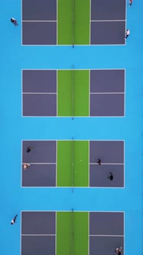 Aerial Topdown View of Multiple Pickleball Courts with Players Engaged in a Match The Vibrant Blue