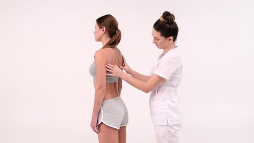 Woman Receiving Back Examination in Clinic