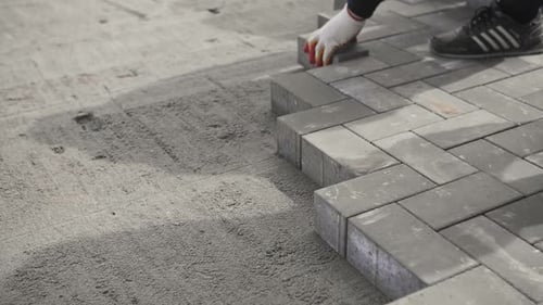 Builder Lays Paving Stones on the Street