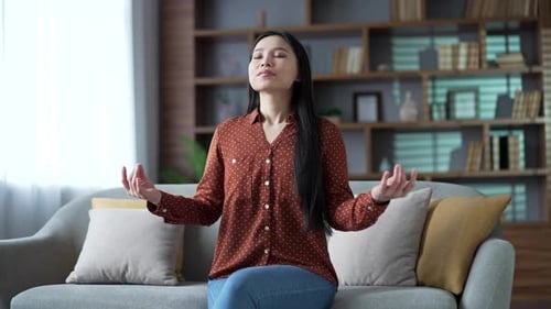 Calm Woman Meditating on Couch at Home