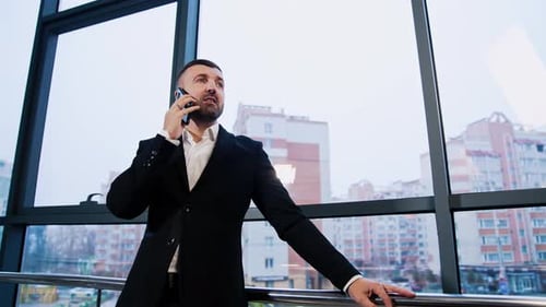 Man in Suit Talking on Phone in Modern Office