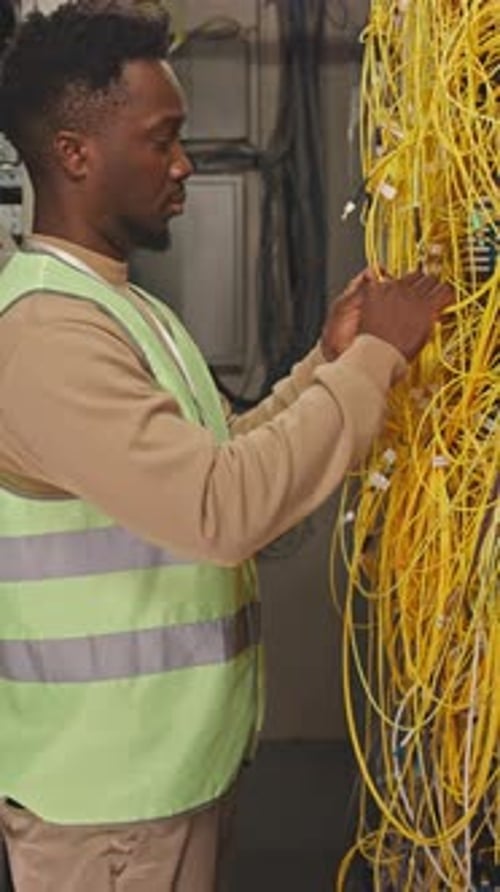 System Administrator Connecting Cables in Data Center
