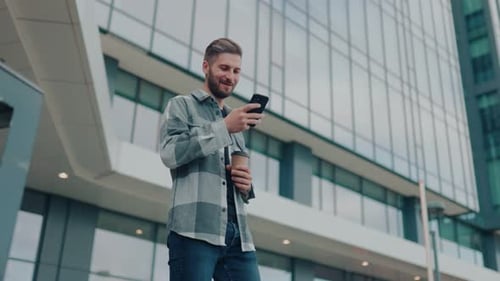 Man Using Phone Outside Modern Office Building