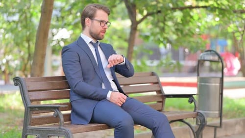 Man in Suit Waiting on Park Bench