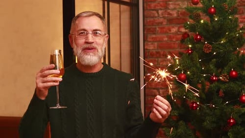 an Elderly Man in a Green Knitted Talking with Family By Phone Video Connection Near the Christmas