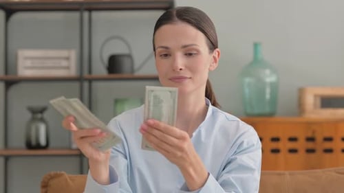 Woman Counting Money in Modern Home Living Room