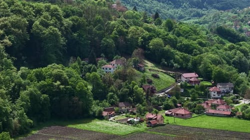 Drone Shot of Countryside Village, Forest on Hills and Agricultural Land in Valley