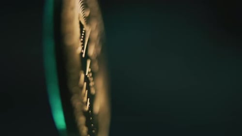 Close Up of Golden Bitcoin Coin Spinning on the Blue Background