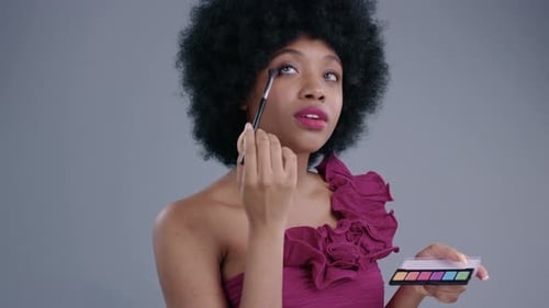 Woman Applying Eye Shadow with Brush and Palette