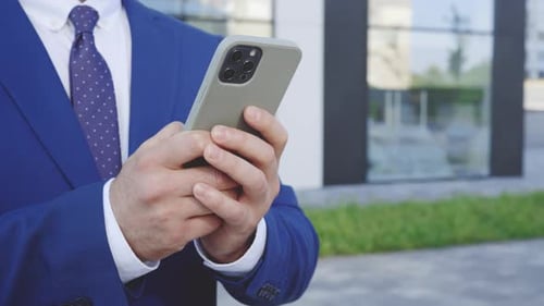 Businessman Using Smartphone Outside Office Building