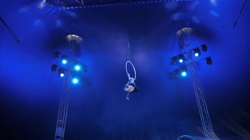 Aerialist Performing on Ring in Dark Blue Tent