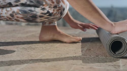 Close Up of Attractive Woman in Sportswear Rolling Up Fitness Mat After