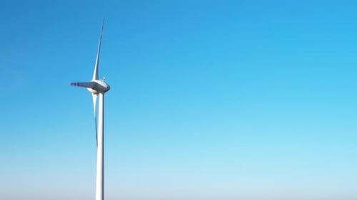 One White and red wind turbine against a blue sky with copy space. Renewable energy concept
