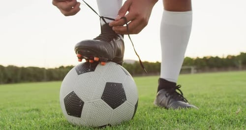 Video of biracial football player with ball tie the laces