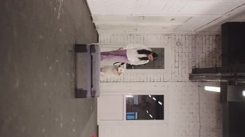 Woman Training White Dog in Indoor Facility