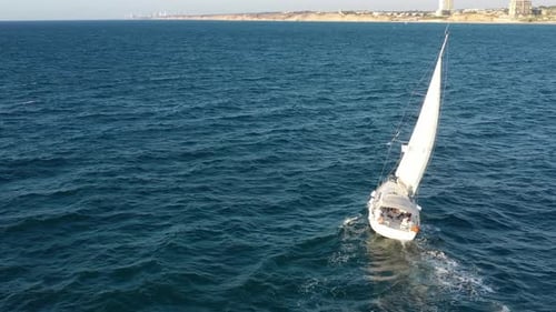 Aerial shot of a yacht sailing across the water