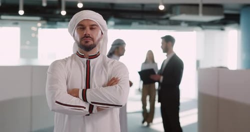 Man in Traditional Dress Stands Confidently in Office