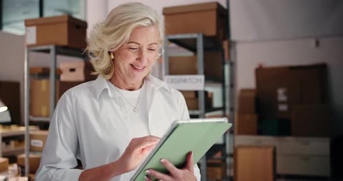 Smiling Woman Using Tablet in Warehouse Setting