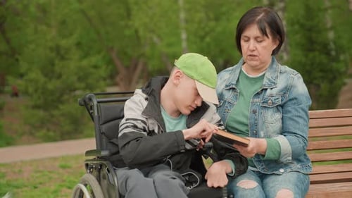 Teen and Woman Reading a Book on Bench