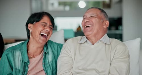 Happy Couple Laughing Together on Sofa