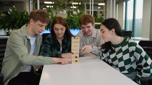 Young Adults Playing Block Game at Office Table