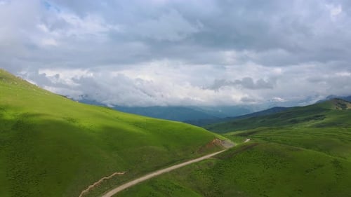 Scenic Road Through Mountains Green Hills Under Blue Sky Offers Breathtaking Journey