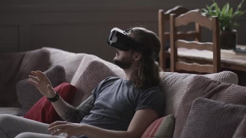 Man Relaxing on Couch Using Virtual Reality Headset