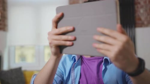 Man Using Tablet for Video Call at Home