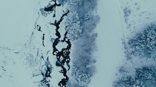 Aerial Drone Shot of Snow Covered River in Forest