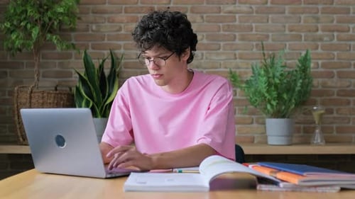 Young Adult Studying with Laptop at Home
