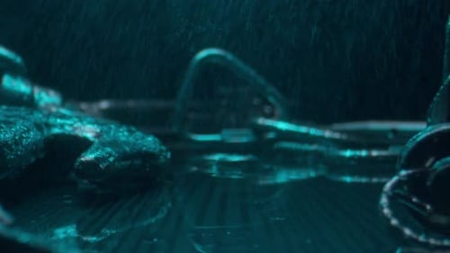 Steel Hooks with Carbines Under Falling Rain in Dark Studio